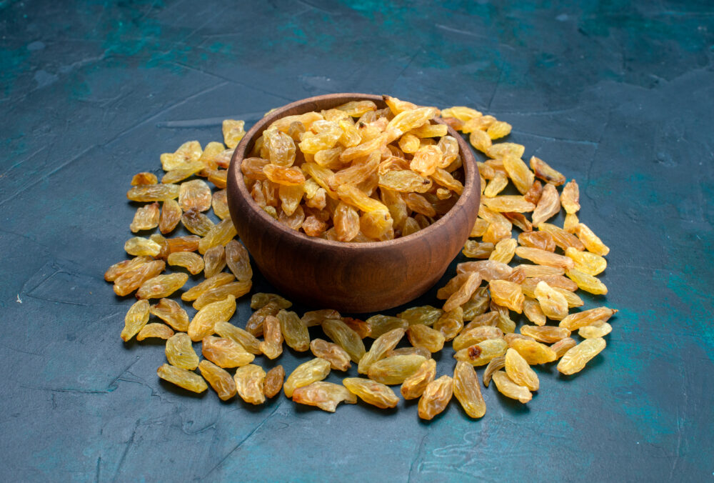 front-view-dried-raisins-inside-outside-brown-pot-blue-background